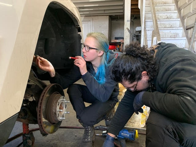 Sebastian Sanchez and Lauren Davidson working on a car